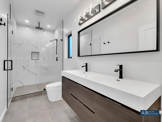 Modern Bathroom Remodel by Alto Builders, bathroom remodel contractor bathroom remodeling in Oceanside, CA - At Alto Builders, we believe that a well-designed bathroom should feel like a private retreat—functional, serene, and visually striking. This recent bathroom remodel exemplifies our dedication to combining contemporary design with meticulous craftsmanship to create a space that enhances daily routines.
The standout feature of this bathroom is its sleek, floating double vanity in rich wood tones, paired with clean, white countertops and matte black fixtures. The floating design not only creates a modern aesthetic but also maximizes floor space, adding to the open, airy feel. Above the vanity, a large mirror with integrated lighting adds depth while providing practical illumination.
The shower is a true showpiece, enclosed in clear glass to emphasize its spaciousness and lined with polished, large-format tiles featuring subtle marble veining. A rainfall showerhead and modern black fixtures enhance both comfort and style. The recessed niche provides a practical touch, ensuring that beauty and functionality go hand in hand.
In the adjoining space, the design maintains its clean and minimalist approach, with a single floating vanity and an artistic light fixture that adds personality to the room. Thoughtfully chosen fixtures, such as the streamlined toilet and matte black towel ring, contribute to the cohesive modern theme while ensuring every inch of the space feels intentional.
This remodel demonstrates how Alto Builders transforms ordinary bathrooms into extraordinary spaces. Every element—down to the lighting and tile selection—was chosen to create a harmonious and inviting environment that balances luxury with practicality.
A bathroom is more than just a utility space; it’s a place for relaxation and renewal. This project is a reflection of how we bring our expertise and attention to detail into every remodel, no matter the size or scope. Modern Bathroom Remodel by Alto Builders, bathroom remodel contractor bathroom remodeling in Oceanside, CA - At Alto Builders, we believe that a well-designed bathroom should feel like a private retreat—functional, serene, and visually striking. This recent bathroom remodel exemplifies our dedication to combining contemporary design with meticulous craftsmanship to create a space that enhances daily routines.
The standout feature of this bathroom is its sleek, floating double vanity in rich wood tones, paired with clean, white countertops and matte black fixtures. The floating design not only creates a modern aesthetic but also maximizes floor space, adding to the open, airy feel. Above the vanity, a large mirror with integrated lighting adds depth while providing practical illumination.
The shower is a true showpiece, enclosed in clear glass to emphasize its spaciousness and lined with polished, large-format tiles featuring subtle marble veining. A rainfall showerhead and modern black fixtures enhance both comfort and style. The recessed niche provides a practical touch, ensuring that beauty and functionality go hand in hand.
In the adjoining space, the design maintains its clean and minimalist approach, with a single floating vanity and an artistic light fixture that adds personality to the room. Thoughtfully chosen fixtures, such as the streamlined toilet and matte black towel ring, contribute to the cohesive modern theme while ensuring every inch of the space feels intentional.
This remodel demonstrates how Alto Builders transforms ordinary bathrooms into extraordinary spaces. Every element—down to the lighting and tile selection—was chosen to create a harmonious and inviting environment that balances luxury with practicality.
A bathroom is more than just a utility space; it’s a place for relaxation and renewal. This project is a reflection of how we bring our expertise and attention to detail into every remodel, no matter the size or scope.