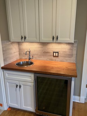 Wet bar remodel - This wet bar was quite functional but needed a facelift. Removed old tile backsplash and countertop, replaced with new wood top, new tile and updated sink. Wet bar remodel - This wet bar was quite functional but needed a facelift. Removed old tile backsplash and countertop, replaced with new wood top, new tile and updated sink.