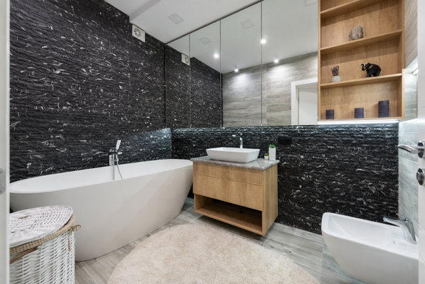 Adoni's Master Bathroom Retreat - Bayshore - A small master bathroom is usually treated as a limitation. It is also the easiest place to make a bold design choice land, because every surface works together. We leaned into a darker, more dramatic palette: dark stone mosaic wall tile for depth and texture, a floating vanity that keeps the floor visually open, a freestanding tub a the centerpiece, and tiled floors tying it together. 45 sq ft, two weeks, $30k. Square footage is not what makes a room feel luxurious. In Adoni's words: Jake and his team were exceptional from start to finish. Full detail is on our website.