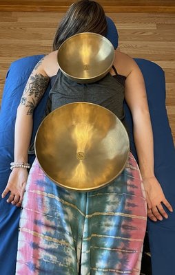 Client with Peter Hess bowls in place for a sound massage - The Peter Hess bowls are placed on the client's body in certain places during the sound massage.