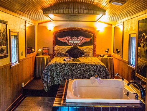Book our Easy Rider Room - If you enjoy riding your Harley Davidson Motorcycle through the beautiful mountain roads and along the shoreline of Clear Lake, then you will definitely enjoy a stay in Easy Rider. Relax in the "Easy Glider" chair complete with saddle bags while you enjoy the Harley touches in this unique caboose. From the orange, black and chrome colors to the custom made headboard with handlebars and the original etched mirror behind the Jacuzzi tub for two, this is definitely a unique and romantic experience.
Climb up to the Cupola for a glass of wine and you'll notice our quarter-scale motorcycle replica displayed in its own black-and-white tiled showroom. But you don't have to be a motorcycle enthusiast to enjoy this suite. WIth its beautiful marbled floors and the smoked mirrors above the bed, this is a romantic retreat for anyone. Call to book today. Book our Easy Rider Room - If you enjoy riding your Harley Davidson Motorcycle through the beautiful mountain roads and along the shoreline of Clear Lake, then you will definitely enjoy a stay in Easy Rider. Relax in the "Easy Glider" chair complete with saddle bags while you enjoy the Harley touches in this unique caboose. From the orange, black and chrome colors to the custom made headboard with handlebars and the original etched mirror behind the Jacuzzi tub for two, this is definitely a unique and romantic experience.
Climb up to the Cupola for a glass of wine and you'll notice our quarter-scale motorcycle replica displayed in its own black-and-white tiled showroom. But you don't have to be a motorcycle enthusiast to enjoy this suite. WIth its beautiful marbled floors and the smoked mirrors above the bed, this is a romantic retreat for anyone. Call to book today.