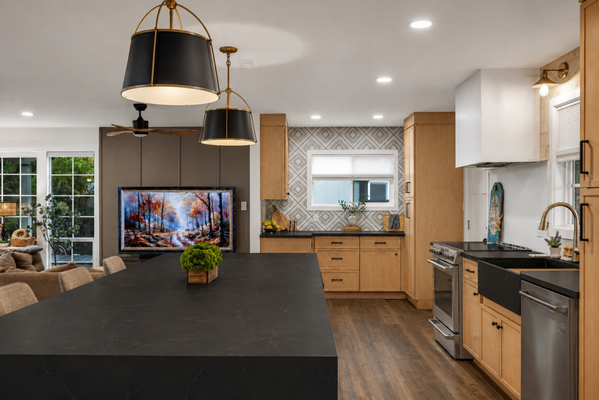 Golden Oak & Black Island Kitchen Remodel - Kitchen remodel featuring warm golden-oak cabinetry, a contrasting dark island, light countertops, updated lighting, stainless-steel appliances, and carefully selected finishes. The redesigned layout creates a warm, functional kitchen with generous seating, improved storage, and a modern open-concept feel. Golden Oak & Black Island Kitchen Remodel - Kitchen remodel featuring warm golden-oak cabinetry, a contrasting dark island, light countertops, updated lighting, stainless-steel appliances, and carefully selected finishes. The redesigned layout creates a warm, functional kitchen with generous seating, improved storage, and a modern open-concept feel.