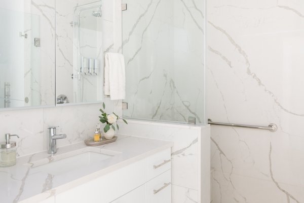Guest Bathroom Remodel-Bellevue - A white guest bathroom featuring wall-to-wall quartz offers a clean, luxurious feel, while incorporating accessible design elements like a built-in bench and a sturdy grab bar ensures both style and safety. The seamless quartz surface adds elegance and easy maintenance, and the addition of accessibility features makes the space welcoming and functional for all guests. Guest Bathroom Remodel-Bellevue - A white guest bathroom featuring wall-to-wall quartz offers a clean, luxurious feel, while incorporating accessible design elements like a built-in bench and a sturdy grab bar ensures both style and safety. The seamless quartz surface adds elegance and easy maintenance, and the addition of accessibility features makes the space welcoming and functional for all guests.