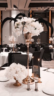 Great Gatsby themed Gala - This was a black elegance, Great Gatsby themed 3rd annual gala/awards ceremony for 600 guests.
We created 4 different centerpiece ideas for 66 tables, outfitted each chair with black chair covers, awards table styling, as well as a custom backdrop for award winners to commemorate the event. Great Gatsby themed Gala - This was a black elegance, Great Gatsby themed 3rd annual gala/awards ceremony for 600 guests.
We created 4 different centerpiece ideas for 66 tables, outfitted each chair with black chair covers, awards table styling, as well as a custom backdrop for award winners to commemorate the event.