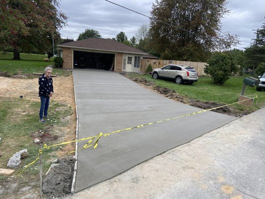 Marys Driveway - Site Preparation: The first step is to prepare the site where the driveway will be installed. This involves clearing the area of any obstacles, removing any existing pavement or debris, and grading the area to ensure proper drainage.

Base Installation: Once the site is prepared, a layer of aggregate material is typically installed to serve as the base for the driveway. This material is usually a mixture of crushed rock, sand, and gravel that is compacted to create a solid base.

Forms and Reinforcement: Next, forms are typically installed along the edges of the driveway to create the shape and size of the finished product. Reinforcement, such as wire mesh or rebar, is often added to provide additional strength and durability to the driveway.

Concrete Placement: The concrete is then poured onto the prepared site, leveled, and smoothed. It is usually finished with a broom or trowel to create a non-slip surface and add texture.

Curing and Sealing: After the concrete is placed, it needs time to cure and harden. This process can take several days to a week, depending on the weather conditions. Once the concrete has cured, a sealant is typically applied to protect the surface from damage and preserve its appearance.

The specific details of Mary's driveway installation would depend on the size and complexity of the project, as well as the type of concrete used and any unique design features or finishes requested. It's important to work with a reputable contractor who has experience in driveway installation to ensure the project is completed safely and to a high standard of quality.
