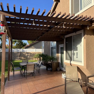 Lowered an existing pergola to add slope for new cover . - This patio cover needed some love , dry rot and water damage we were able to salvage most and repair the rest as well as add a new cover and re paint .