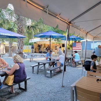 Live Music! - JT's always features family friendly live music every Friday and Saturday year round and every day during the season February through August. Come enjoy the best of Central Florida's music scene. Whether its seasoned local performers or up and coming new acts, you'll see it all at JT's. Our spacious outdoor dining area and stage bar are covered so a little Florida dew doesn't stop the fun. Your children are welcome to enjoy our large sandpit/play area, which is safely visible from the dining area, while you enjoy your meal and the tunes. Live Music! - JT's always features family friendly live music every Friday and Saturday year round and every day during the season February through August. Come enjoy the best of Central Florida's music scene. Whether its seasoned local performers or up and coming new acts, you'll see it all at JT's. Our spacious outdoor dining area and stage bar are covered so a little Florida dew doesn't stop the fun. Your children are welcome to enjoy our large sandpit/play area, which is safely visible from the dining area, while you enjoy your meal and the tunes.