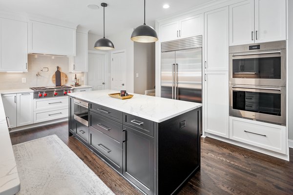 Transitional Kitchen Remodel - Transitional kitchen remodel. Black shaker cabinets. Marble countertops. White shaker cabinets. Tile backsplash. Island with seating.