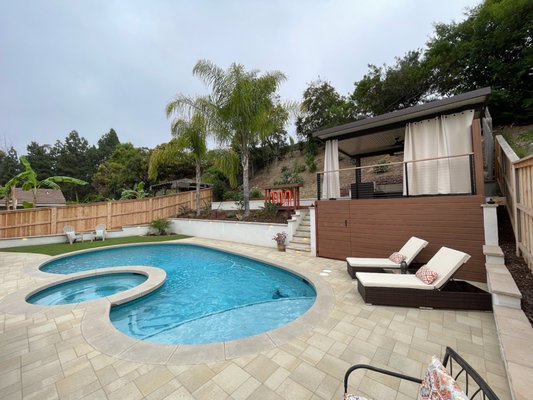 RP Backyard Design + Build - This project is a full design and build backyard remodel including pushing back the hillside with a retaining wall to gain more space around the pool area, multiple concrete masonry retaining walls and terraced retaining wall on the hillside, Upper deck with Trex materials, seating counter on the upper deck area, Alumawood Patio cover on the upper deck, Paver pool deck, Cable handrails, an L-shaped BBQ Island/outdoor kitchen area, artificial turf, low voltage lighting, and low maintenance landscaping.