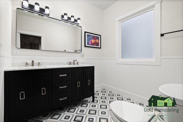 Modern Black & White Bathroom Remodel – East Bay - This complete bathroom remodel features a timeless black-and-white design with modern finishes and clean architectural details.
We installed a custom double vanity with black shaker cabinetry, a marble-look quartz countertop, and brushed nickel widespread faucets. The oversized framed mirror and upgraded LED lighting create a bright, balanced space.
The geometric patterned tile flooring adds character while keeping the look classic and resale-friendly. The walk-in shower was finished with large-format porcelain wall tile, hex-pattern shower flooring, built-in corner shelves, and a sleek frameless glass enclosure.
This project was completed with attention to detail, durability, and long-term value — from demo to final finishes.
📍 Designed & Built by GOLD Remodeling Inc.
Licensed & Insured | Class B General Contractor
Serving the Bay Area