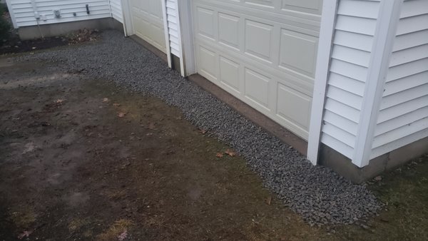 Stone install - The immediate area in front of the garage had lowered over time due to washout.  Dug it out and installed crushed stone up to the level of the garage.