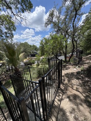 Hill Country 4'H Ornamental Fence - On this project, we fenced-in a terraced area of a large corner lot in the Austin hills with 4 ft. tall two-rail flat-top, flat-bottom gloss-black ornamental steel fence panels and 2"x2" square steel posts with dome caps. Hill Country 4'H Ornamental Fence - On this project, we fenced-in a terraced area of a large corner lot in the Austin hills with 4 ft. tall two-rail flat-top, flat-bottom gloss-black ornamental steel fence panels and 2"x2" square steel posts with dome caps.