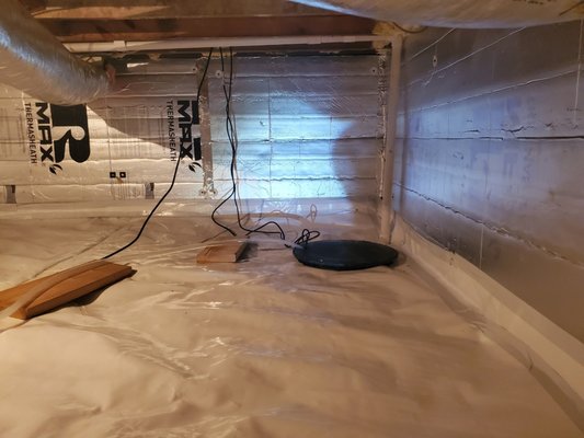 Crawlspace Encapsulation and Insulation - This crawlspace was cold and drafty.  In the summer, humidity would travel through the floor to the room above.  We insulated the walls, encapsulated the floor, added interior drainage and a sump pump, and included a dehumidifier.  This space is now more healthy and comfortable.