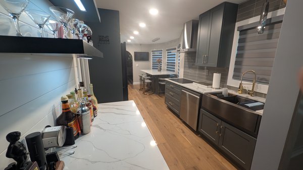 Stone Mountain Kitchen Remodel - ✨ We are thrilled to showcase our latest project—a stunning transformation that joins the kitchen and dining room into a beautiful, open space for entertaining! ✨ 

Our team handled a complete overhaul, removing the wall that divided both areas to create a seamless flow. We designed a new wet bar complete with a built-in mini fridge to enhance the functionality and style of the space. 

Featuring custom color shaker-style cabinets and warm engineered wood flooring, this kitchen exudes modern elegance. The glass tile backsplash sparkles, adding a touch of brilliance to the overall design. 🏡💖 

Additionally, we created a custom sit-in island for gatherings and installed custom window blinds to provide privacy when needed. With plenty of recessed ceiling lights on dimmers and under-cabinet lighting, we’ve set the perfect ambiance for any occasion. 

Transform your home with us! 🛠️
