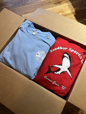 Sandbar Grill Rebrand and Printing - This rebranding was done with a customer of ours who wanted to give his bar a new feel. With these tees and tanks people would feel the Coconut Grove vibe. Heat, drinks and happy customers are in this bars plans, and light tank tops with vibrant colors were the answer.