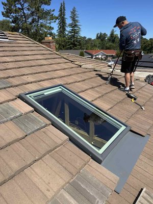 Velux Skylight Replacement – Carmichael, CA - Complete replacement of an outdated leaking skylight on a concrete tile roof in Carmichael, CA. Our team removed the old skylight, repaired damaged roof decking, built a new frame, installed the Velux waterproofing membrane system, custom flashing kit, and a new Velux solar-powered skylight with remote-controlled blind. The surrounding tile roof was repaired and cleaned upon completion. Velux Skylight Replacement – Carmichael, CA - Complete replacement of an outdated leaking skylight on a concrete tile roof in Carmichael, CA. Our team removed the old skylight, repaired damaged roof decking, built a new frame, installed the Velux waterproofing membrane system, custom flashing kit, and a new Velux solar-powered skylight with remote-controlled blind. The surrounding tile roof was repaired and cleaned upon completion.