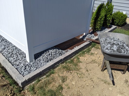 Back Yard Privacy - A professionally landscaped backyard patio designed to create a private outdoor oasis. The central feature is a hot tub, discreetly enclosed by a clean white privacy fence. Surrounding the hot tub, a meticulously arranged bed of decorative black shale adds a sleek, modern touch, while a border of neatly placed stones adds definition to the area. To enhance the space's visual appeal and natural feel, attractive arborvitae have been planted along the edge, providing a lush green backdrop that contrasts beautifully with the dark stones. This combination of elements creates a tranquil, visually pleasing retreat within the yard. Back Yard Privacy - A professionally landscaped backyard patio designed to create a private outdoor oasis. The central feature is a hot tub, discreetly enclosed by a clean white privacy fence. Surrounding the hot tub, a meticulously arranged bed of decorative black shale adds a sleek, modern touch, while a border of neatly placed stones adds definition to the area. To enhance the space's visual appeal and natural feel, attractive arborvitae have been planted along the edge, providing a lush green backdrop that contrasts beautifully with the dark stones. This combination of elements creates a tranquil, visually pleasing retreat within the yard.
