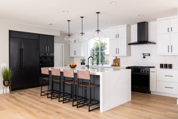 Sultry Contemporary Kitchen Remodel In Irvine - Timeless, bold, and elegant, something about the monochrome look just screams sophistication. With clean lines and a simple design, black and white kitchens are a classic choice. This contemporary kitchen remodel in Irvine dared to team black and white with warm wood floors for a smart and sultry look.

Contemporary kitchens embrace modern design with a mix of minimalism. This kitchen features flat front ‘wrought iron’ black cabinets with honey bronze pulls on one wall and ‘Chantilly lace’ white cabinets with matte black pulls on the other. A sleek black refrigerator and built in microwave-oven blend seamlessly into the cabinetry. The kitchen island brings a dramatic look with black cabinetry matched with polished white quartz countertops and a waterfall edge that cascades seamlessly to the floor. A matte black and luxe gold Brizo Litze wall-mounted pot filler sits atop a counter to ceiling polished quarts backsplash in Calacatta Plata. The pantry was redesigned with floating white oak shelves, under cabinet LED lighting and custom cabinetry including unique modular pull-out drawers. The use of engineered European Oak wood floors warms up the kitchen and acts as a mediator between the black and white cabinets. 

The staircase received a dramatic transformation with new stair treads, a white oak post-to-post handrail system and iron balusters in satin black. A custom nook was carved out to include floating shelves, puck lights, and new slimline cabinetry with honey bronze pulls topped with a white quartz counter. 

Completely refurbished from floor to ceiling, the fireplace features Hawi dark grey ceramic tiles with a concrete wave effect and a matte finish. The hearth features slick concrete grey, DCOF certified, porcelain tiles and a bi-fold glass fireplace door in matte black.

If you’re planning your own kitchen remodel in Irvine or any other home remodeling project in Orange County, Sea Pointe Design & Remodel has you covered! We’ve been meeting the remodeling needs of Orange County residents for over 35 years and we’d love to remodel YOUR home next. Simply give us a call at (949) 749-5619 or fill out the form below to schedule your complimentary design consultation.