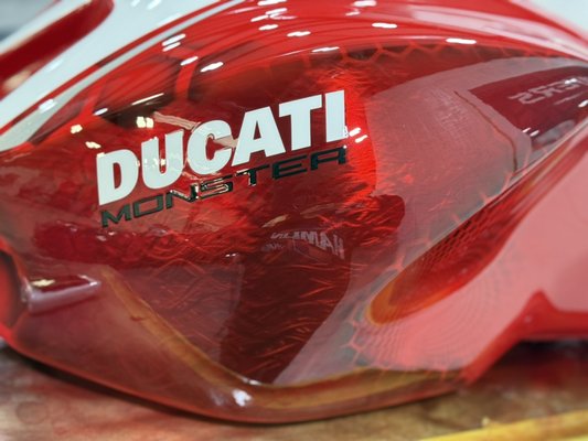 Fuel tank Ducati Monster 1200 - The customer brought in a fuel tank with a large dent on the top. We repaired the tank and gave it a Ducati-inspired look with a touch of Prolayers style. Fuel tank Ducati Monster 1200 - The customer brought in a fuel tank with a large dent on the top. We repaired the tank and gave it a Ducati-inspired look with a touch of Prolayers style.