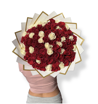 Divine Bouquet - An impressive bouquet of premium red and white roses, arranged in a circular design that symbolizes passion and purity. Wrapped in elegant paper with golden edges, this arrangement is the perfect choice to express love, admiration, and elegance on any special occasion.