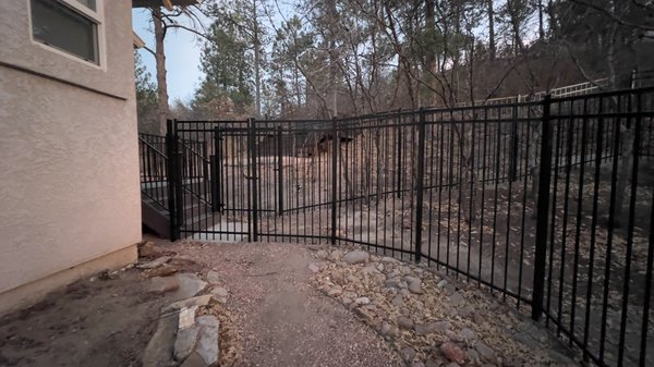 Ornamental steel fence Dog Run Install - This custom ornamental steel fence is a beautiful strong sturdy black fence. Used to build a dog run for client. We were able to create an inclosed space with no holes for dogs to escape. Including two convenient fences with easy access. Working around conditions such as Rocky ground, hills and trees. Loved the turnout of this project, highly recommend for clients looking for a beautiful fence to stand out and bring value to home! Ornamental steel fence Dog Run Install - This custom ornamental steel fence is a beautiful strong sturdy black fence. Used to build a dog run for client. We were able to create an inclosed space with no holes for dogs to escape. Including two convenient fences with easy access. Working around conditions such as Rocky ground, hills and trees. Loved the turnout of this project, highly recommend for clients looking for a beautiful fence to stand out and bring value to home!