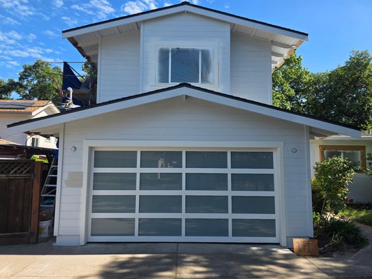 Alumadoor Full View Door Installation - New construction garage door installation with Alumadoor Full View Door. Painted white frame with white laminated glass. Alumadoor Full View Door Installation - New construction garage door installation with Alumadoor Full View Door. Painted white frame with white laminated glass.