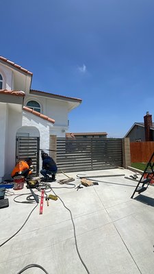 Rialto Custom Swing Gates - These custom gate installations were done on a beautiful multi-family property that was rehabbed in Rialto, California. This was a challenging and awesome project. We installed a 3’ wide pedestrian gate and two 13’ wide swing gates with 1/4” 4”x4” posts. Every portion of this project was sent to powder coating. The real challenge began when delivering these gates as well as installing them due to both swing gates weighing just over 700 pounds each. The gate operator installed on the automatic gate was an Liftmaster RSW12UL motor with a Liftmaster MG1300 magnet and 2 reflective photo eye sensors Rialto Custom Swing Gates - These custom gate installations were done on a beautiful multi-family property that was rehabbed in Rialto, California. This was a challenging and awesome project. We installed a 3’ wide pedestrian gate and two 13’ wide swing gates with 1/4” 4”x4” posts. Every portion of this project was sent to powder coating. The real challenge began when delivering these gates as well as installing them due to both swing gates weighing just over 700 pounds each. The gate operator installed on the automatic gate was an Liftmaster RSW12UL motor with a Liftmaster MG1300 magnet and 2 reflective photo eye sensors