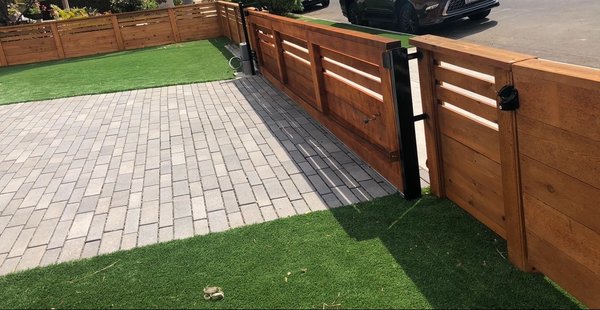 Driveway Creation with Automatic Doors - We installed a new cement driveway with artificial turf on the sides. The doors are made of redwood and are paired with an automatic switch to easily open and close the driveway entrance. Want different materials or have something else in mind? Feel free to call us or leave and email!