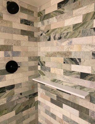 Guest Bathroom Remodel - This guest bathroom was transformed from a dated 1970s space into a stunning, spa-like retreat. The original design, with its beige tones and lack of character, was completely reimagined to create a luxurious experience for guests.

Key to the remodel was incorporating the clients' vision for elegance and texture: modern meets nature. The shower walls feature hand-selected green Caribbean marble tile, delivering a breathtaking "wow" factor with its intricate veining and natural beauty. The black trim details provide a modern edge that ties seamlessly with the fixtures throughout the home, creating continuity in design. Hexagonal floor Clé tiles add a subtle geometric touch, balancing the bold statement of the shower.

Every element was thoughtfully chosen to elevate the space while maintaining a cohesive, sophisticated look. The result is a bathroom that feels inviting, serene, and unforgettable—a perfect blend of style and function.