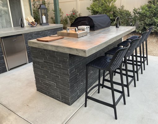 BBq Island - These BBQ and prep Islands were built out of metal framing and concrete. The sides are a beautiful slate stacked stone. Countertops are a raw poured in place concrete with a smooth sealed finish. The 32” 4 burner gas grill is Lion premium grills as well as the side burner and built in mini fridge. We also did a concrete planter that you can see in the background of one of the photos. BBq Island - These BBQ and prep Islands were built out of metal framing and concrete. The sides are a beautiful slate stacked stone. Countertops are a raw poured in place concrete with a smooth sealed finish. The 32” 4 burner gas grill is Lion premium grills as well as the side burner and built in mini fridge. We also did a concrete planter that you can see in the background of one of the photos.