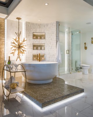 Award-Winning Luxury Condo Bathroom Remodel - We are very excited to announce that this Luxury Condo Bathroom Remodel won NARI’s Region 5 South Central 2024 Regional CotY Winner for Gold in the Residential Bath $100,000 – $150,000 category, and also won Best of Show.
Even when you extensively travel the world, like this homeowner that ArDan Construction recently worked with, you want your home to suit your needs and express your taste. ArDan Construction teamed up with Modascapes Interior Design once again to deliver this truly spectacular luxury bathroom remodel. Since this home is a condo within a multi-family structure, there were limitations in terms of plumbing and other infrastructure changes that we were able to make. Using the existing plumbing and drainage placement, we were able to bring this stunning vision to life including floating, backlit granite slabs and a waterfall countertop. Award-Winning Luxury Condo Bathroom Remodel - We are very excited to announce that this Luxury Condo Bathroom Remodel won NARI’s Region 5 South Central 2024 Regional CotY Winner for Gold in the Residential Bath $100,000 – $150,000 category, and also won Best of Show.
Even when you extensively travel the world, like this homeowner that ArDan Construction recently worked with, you want your home to suit your needs and express your taste. ArDan Construction teamed up with Modascapes Interior Design once again to deliver this truly spectacular luxury bathroom remodel. Since this home is a condo within a multi-family structure, there were limitations in terms of plumbing and other infrastructure changes that we were able to make. Using the existing plumbing and drainage placement, we were able to bring this stunning vision to life including floating, backlit granite slabs and a waterfall countertop.