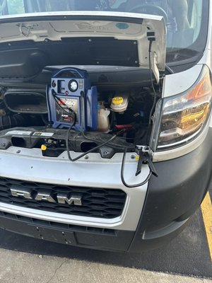 Jumpstart service. Medium duty vehicle - Jumpstart being performed on medium and regular size vehicle.