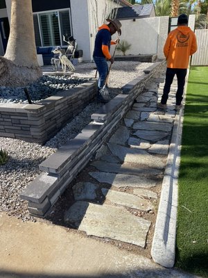 Retaining wall - Customer called asked us to match the same block and colorway and add a small retaining wall to separate the rocks and the walkway. Retaining wall - Customer called asked us to match the same block and colorway and add a small retaining wall to separate the rocks and the walkway.