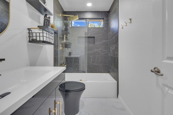 Guest Bathroom - Chula Vista - We recently completed a stunning guest bathroom remodel in Chula Vista. The space was transformed with sleek black fixtures that add a touch of modern elegance. A brand-new tub, paired with a crystal-clear glass door, creates a luxurious bathing experience. The updated vanity provides both style and functionality, while the fresh flooring and new tile design tie the entire room together beautifully. This bathroom now exudes a contemporary charm that's both inviting and sophisticated.