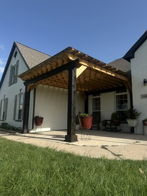 Sealy Cedar Pergola Project - This project was done in Sealy Texas to the front porch of a house. It is made of Cedar wood, with large 8x8 posts and a Hercules polycarbonate cover for the top.
