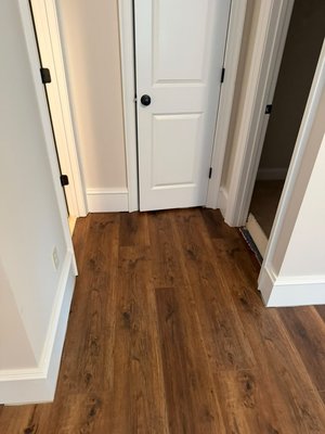 Project #204 - This LVP flooring project brought a warm, rich wood-look finish to the space, creating a clean and updated feel throughout. The installation was completed across multiple areas, including bedrooms, hallway, and main living spaces, giving the home a cohesive and durable new surface. The darker tone of the flooring adds depth and character while still keeping the rooms bright and inviting.