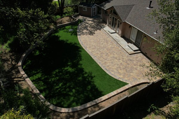 Patio of your dreams - Beautiful Calstone Quarry Stone pavers with natural looking synthetic lawns, and a gorgeous seating wall to retain planter soil.
