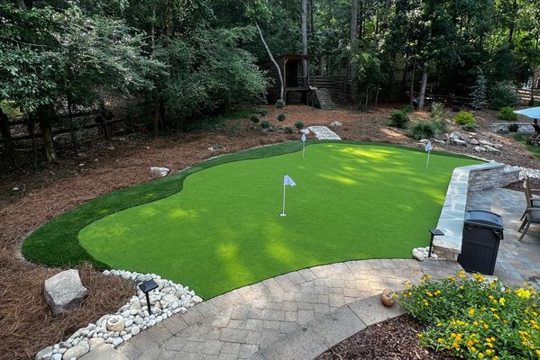 Backyard Putting Green - If you're looking to improve your golf game without leaving the comfort of your home, installing a putting green in your backyard may be the perfect solution. The installation process typically involves removing grass and soil, adding a layer of crushed rock for drainage, and finally, laying down artificial turf. To create a more authentic feel, some homeowners may choose to add sand traps or other obstacles around the green. With proper maintenance and care, a backyard putting green can provide endless hours of entertainment and practice for golfers of all levels. Backyard Putting Green - If you're looking to improve your golf game without leaving the comfort of your home, installing a putting green in your backyard may be the perfect solution. The installation process typically involves removing grass and soil, adding a layer of crushed rock for drainage, and finally, laying down artificial turf. To create a more authentic feel, some homeowners may choose to add sand traps or other obstacles around the green. With proper maintenance and care, a backyard putting green can provide endless hours of entertainment and practice for golfers of all levels.