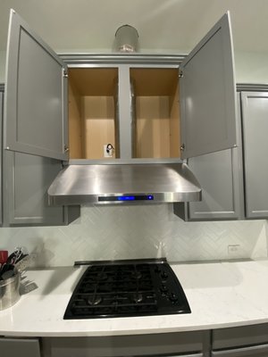 Ducted 36” range hood (500 CFM) install + 8-inch duct & roof vent - Our customer wanted to upgrade from a non-ducted range hood to this Cosmo COS-QS90 (500 CFM) model. This unit was substantially heavy (63lbs) and needed to be blocked both under the cabinet and to the tile backsplash to support it properly. The 8-inch steel ductwork is routed through the cabinet, ceiling, through the attic and to the roof. Ducted 36” range hood (500 CFM) install + 8-inch duct & roof vent - Our customer wanted to upgrade from a non-ducted range hood to this Cosmo COS-QS90 (500 CFM) model. This unit was substantially heavy (63lbs) and needed to be blocked both under the cabinet and to the tile backsplash to support it properly. The 8-inch steel ductwork is routed through the cabinet, ceiling, through the attic and to the roof.