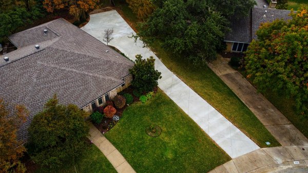 Wider, Smarter Driveway Upgrade (Carrollton, TX) - The old driveway was worn down and tight to maneuver, so we removed it and rebuilt a new, wider layout designed for easier everyday use. The new slab runs long and then expands near the garage, giving the homeowner space to back out and pull forward without squeezing or turning in the yard.
We poured a reinforced, broom-finish driveway and finished it with precision diamond-pattern saw-cut joints for a clean, elevated look that stands apart from standard residential flatwork.
A practical upgrade, done with intention — built to last and built to look good.