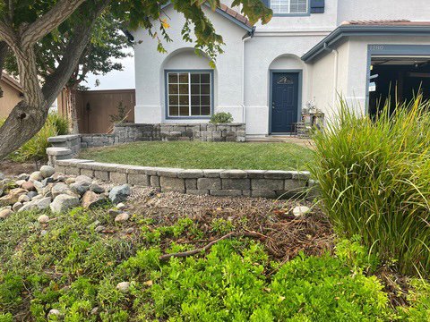 Retaining Wall + Garden Bed. - Client had a small out of maintenance garden bed in front of house enclosed by 6 in tall stone edging. They wanted to beef up the garden bed while delineating the yard somehow. We came up with this tiered wall design to add depth to the bed and give the whole yard style.