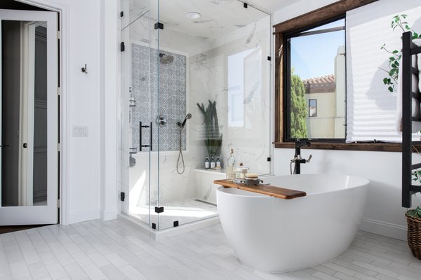 Four Newport Coast Bathroom Remodels Under One Roof - Known as one of today's most popular style trends, Modern Designs encompass "form ever following function". It can invite clean aesthetics with warm natural tones in a sleek yet elegant touch. To help inspire your next bathroom remodel, check out these four bathrooms that were part of a whole home remodel, featuring chic timeless updates with global appeal.

Pool/ Guest Bathroom
Starting downstairs, our clients realized they needed to create outside access to a bathroom when entertaining guests for pool parties. Our designers utilized an outdated ensuite bathroom, added an exterior entrance and expanded the bathroom into a closet. Stepping through a black door with a frosted glass insert, the new pool bathroom looks stunning featuring porcelain black tile flooring, white Omega dynasty cabinets and black marble quartz countertops. Blending fun shapes with neutral colors, a square black metal frame mirror reflects upon a white circular vessel sink including a deck mounted faucet in matte black. The bathroom also includes a walk-in shower featuring a built-in shampoo niche and a bench for resting in marble and white subway porcelain tiles.

Powder Bathroom
A small downstairs powder room was also completely redesigned in a similar style including Omega Dynasty cabinets in an Amalfi finish. The white quartz countertop includes a small backsplash including teak wood and matte black faucets wall mounted above a vessel sink. Completing the look is a white shiplap backsplash with floating shelves and a nautical light pendant.

Jack & Jill Bathroom
With the addition of a second story bonus room and guest bedroom, a Jack and Jill bathroom was created. Each room is divided by beautifully stained barn doors on a sliding track. The brand-new Jack and Jill bathroom features a walk-in shower sectioned off by a pony wall and a single pane of glass. The showers are lined in a wood-like porcelain tile tying in the marble-like porcelain flooring. The double vanity features Omega Dynasty cabinets in an Amalfi finish with white quartz stone countertops and a white shiplap backsplash. Adding a nautical nod to this farmhouse vibe are two black metal framed circular mirrors and unique wall mounted faucet handles.

Primary Bathroom
Finally, the Primary bathroom was completely renovated from head to toe featuring a stand-alone tub, soaking in the ocean views and a walk-in steam shower. The large spa-like shower steals the show with a marble accent inset in a blue silver patterned tile. The large shower features a built-in shampoo niche, a quartz topped bench, and a linear drain in a luxurious polished Calacatta porcelain tile.  The rain shower-head and hand shower kit in luxe nickel and matte black correspond with the vanity faucets and in-floor tub filler. Following the white crackle porcelain tiles floors to the opposite end of the room sits an attractive double vanity with Omega full access cabinets including a tandem full extension undermount and Amara grey quartz countertops. Creating additional storage space and completing the look are floor to ceiling custom Omega tower cabinets in a rain finish.

Whether you’re planning a bathroom remodel in Newport Coast or a remodeling project in any other Orange County locale, Sea Pointe Design & Remodel has you covered. With over 35 years of experience in the remodeling industry, our design and build experts have exactly what it takes to make your dream remodel become a reality. Simply give us a call at (949) 749-5763 or fill out the form below to schedule your complimentary design consultation.