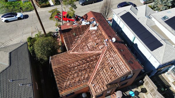 Reroof Wood Shake To Asphalt Shingles - Complete roof replacement involving tear-off of two existing layers-wood shake and asphalt shingles down to the skip sheathing. Installed new plywood decking and finished with high-quality asphalt shingles for a durable, updated roofing system.