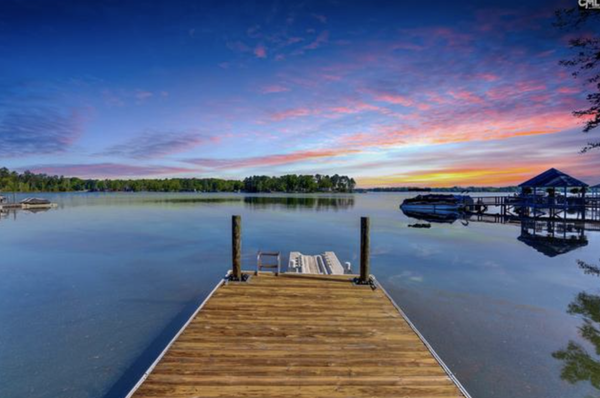 MLS# 515109 100 Quiet Cove Drive Chapin, SC 29036 $ 780,000 - 4 Bed, 3 Bath, 1 Half - 2945 Square Feet - Acres - GORGEOUS ALL BRICK HOME WITH SHARED DOCK ON LAKE MURRAY, TUCKED AWAY IN DESIRABLE TIMBERLAKE COMMUNITY! This 5 bedroom/3.5 bath home is full of beautiful features including hardwood throughout the living spaces! Natural light spills throughout the flowing layout as you move with ease from one room to the next. The large living room offers stunning lake views, cozy fireplace and easy access to the kitchen! The spacious and bright eat-in kitchen boasts a bay window, large island and tons of counter and cabinet space making cooking a breeze! The owner's suite on the main floor offers a walk-in closet and spa-like en suite with soaking tub and double vanity! Each additional bedroom offers ample closet space and lovely shared full bath. The 5th bedroom would make a perfect teen or in-law suite with private bath! Enjoy relaxing or entertaining on the huge deck or gorgeous patio that look out onto the plush backyard and big lake views! MLS# 515109 100 Quiet Cove Drive Chapin, SC 29036 $ 780,000 - 4 Bed, 3 Bath, 1 Half - 2945 Square Feet - Acres - GORGEOUS ALL BRICK HOME WITH SHARED DOCK ON LAKE MURRAY, TUCKED AWAY IN DESIRABLE TIMBERLAKE COMMUNITY! This 5 bedroom/3.5 bath home is full of beautiful features including hardwood throughout the living spaces! Natural light spills throughout the flowing layout as you move with ease from one room to the next. The large living room offers stunning lake views, cozy fireplace and easy access to the kitchen! The spacious and bright eat-in kitchen boasts a bay window, large island and tons of counter and cabinet space making cooking a breeze! The owner's suite on the main floor offers a walk-in closet and spa-like en suite with soaking tub and double vanity! Each additional bedroom offers ample closet space and lovely shared full bath. The 5th bedroom would make a perfect teen or in-law suite with private bath! Enjoy relaxing or entertaining on the huge deck or gorgeous patio that look out onto the plush backyard and big lake views!