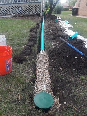 Sump pump discharge line and downspout extention. - Leading your sump pump discharge line and down spouts as far away from the home as possible will help with the amount of water around your home's foundation. We bury our lines, to avoid trip hazards and lawn care mishaps, and discharge to a bubbler pot. Sump pump discharge line and downspout extention. - Leading your sump pump discharge line and down spouts as far away from the home as possible will help with the amount of water around your home's foundation. We bury our lines, to avoid trip hazards and lawn care mishaps, and discharge to a bubbler pot.