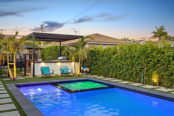 Hawthore - Outdoor Oasis! This backyard landscape design and construction added an outdoor kitchen with a steel pergola, synthetic turf, poured in place colored concrete, retaining walls, plantscaping, lighting and pool and spa with a baja shelf. A dream backyard for this Hawthorne property. Hawthore - Outdoor Oasis! This backyard landscape design and construction added an outdoor kitchen with a steel pergola, synthetic turf, poured in place colored concrete, retaining walls, plantscaping, lighting and pool and spa with a baja shelf. A dream backyard for this Hawthorne property.