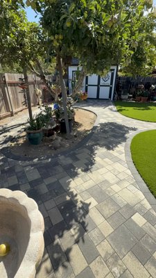 Backyard Pavers and Turf "Full Remodel" - Full backyard transformation designed to turn a bare, underutilized space into a clean, functional, and inviting outdoor living area.
We started by demoing and grading the existing dirt yard, carefully mapping out the layout to maximize flow and usability. A custom paver system was installed throughout the space using a multi-size pattern, finished with a darker border for contrast and definition. The curved walkways were designed to guide movement naturally through the yard while creating a soft, high-end look.
A raised circular planter was built around the existing tree using decorative block, creating a focal point and adding structure to the space. We also incorporated additional planting areas and decorative river rock to enhance drainage and give the yard a polished finish.
Premium artificial turf was installed to provide a lush, green lawn year-round with zero maintenance. The turf areas were strategically shaped to complement the paver layout and create a balanced, open feel.
This project also ties seamlessly into the existing patio area, giving the homeowner a complete outdoor space perfect for relaxing and entertaining.
From dirt to a fully finished landscape, this is a great example of how thoughtful design and quality installation can completely transform a backyard.
Looking to upgrade your yard? Contact us to schedule your in-home estimate. Backyard Pavers and Turf "Full Remodel" - Full backyard transformation designed to turn a bare, underutilized space into a clean, functional, and inviting outdoor living area.
We started by demoing and grading the existing dirt yard, carefully mapping out the layout to maximize flow and usability. A custom paver system was installed throughout the space using a multi-size pattern, finished with a darker border for contrast and definition. The curved walkways were designed to guide movement naturally through the yard while creating a soft, high-end look.
A raised circular planter was built around the existing tree using decorative block, creating a focal point and adding structure to the space. We also incorporated additional planting areas and decorative river rock to enhance drainage and give the yard a polished finish.
Premium artificial turf was installed to provide a lush, green lawn year-round with zero maintenance. The turf areas were strategically shaped to complement the paver layout and create a balanced, open feel.
This project also ties seamlessly into the existing patio area, giving the homeowner a complete outdoor space perfect for relaxing and entertaining.
From dirt to a fully finished landscape, this is a great example of how thoughtful design and quality installation can completely transform a backyard.
Looking to upgrade your yard? Contact us to schedule your in-home estimate.