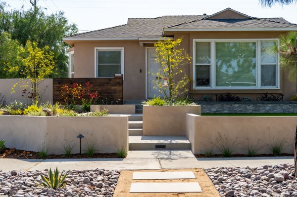 Corner Lot Transformation - The client asked us to help them put together a design for their front and side yard. One of the main features they sought, yet somewhat of an obstacle, was privacy. We had to take into account that this is a corner lot with multiple setbacks.
Another big obstacle was the huge grade difference between the foundation of the house and the street, roughly about 3’ difference. Therefore, we had to design a space with retaining walls and figure out a way to install paths that will not loose aesthetic appeal, functionality, and look natural.
As usual, we began with an initial concept and rendered the project in some 3D images using our software prior to construction. The process to dial in what the customer wanted lasted roughly about a month. Once the client agreed with our design, we provided them with a quote. The client did not get to us on approval of the project until 4 months later.
The commencement of the scope of work began with us taking out three 16-yard truckloads of soil to level and grade the space.
Once the demolition was completed, we moved towards digging all of our trenches for drainage, irrigation, gas, and low volt lighting. We also started to dig the footing for the walls. The side yard wall footing had to deeper than usual because of its proximity to the sidewalk. The city required us to go about 3’ feet. Certainly, that was unexpected because we originally had a different footing template. This caused a small set back on our timeline. Once the walls where up we completed all the forming and pouring of the concrete.
For the stucco work, we had to bring in all of our staff to complete it one day. Roughly 6 of our team members had to get pulled from other projects to complete the stucco.
Once, all the masonry was complete, we took a nursery visit to hand select all of the plants to be installed. The customer also changed her mind several times on the veneer stone. We finally, helped her make a decision on a stone that would pop and contrast.
For the final touch, we finished off the project with lighting installation, planting, and mulching. Corner Lot Transformation - The client asked us to help them put together a design for their front and side yard. One of the main features they sought, yet somewhat of an obstacle, was privacy. We had to take into account that this is a corner lot with multiple setbacks.
Another big obstacle was the huge grade difference between the foundation of the house and the street, roughly about 3’ difference. Therefore, we had to design a space with retaining walls and figure out a way to install paths that will not loose aesthetic appeal, functionality, and look natural.
As usual, we began with an initial concept and rendered the project in some 3D images using our software prior to construction. The process to dial in what the customer wanted lasted roughly about a month. Once the client agreed with our design, we provided them with a quote. The client did not get to us on approval of the project until 4 months later.
The commencement of the scope of work began with us taking out three 16-yard truckloads of soil to level and grade the space.
Once the demolition was completed, we moved towards digging all of our trenches for drainage, irrigation, gas, and low volt lighting. We also started to dig the footing for the walls. The side yard wall footing had to deeper than usual because of its proximity to the sidewalk. The city required us to go about 3’ feet. Certainly, that was unexpected because we originally had a different footing template. This caused a small set back on our timeline. Once the walls where up we completed all the forming and pouring of the concrete.
For the stucco work, we had to bring in all of our staff to complete it one day. Roughly 6 of our team members had to get pulled from other projects to complete the stucco.
Once, all the masonry was complete, we took a nursery visit to hand select all of the plants to be installed. The customer also changed her mind several times on the veneer stone. We finally, helped her make a decision on a stone that would pop and contrast.
For the final touch, we finished off the project with lighting installation, planting, and mulching.