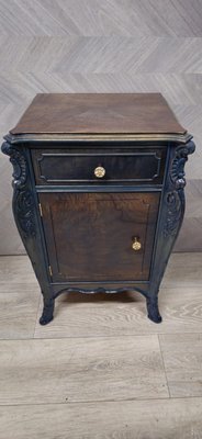 1920 night stand restoration - The restoration of this 1920 nightstand showcases a seamless blend of heritage and modernity. The piece, entitled "Regal Azure Walnut Nightstand," has been meticulously revived, respecting its original craftsmanship. The deep, rich walnut tones are complemented by the azure undertones, highlighting the intricate carvings and elegant contours. The golden knobs add a touch of luxury, accentuating the nightstand's stately presence. This work reflects a dedication to preserving historical elegance while infusing a contemporary charm, making it an exquisite addition to any discerning homeowner's collection. Perfectly suited for bringing a regal ambiance to the bedroom, it stands as a testament to the timeless allure of expertly restored antique furniture.