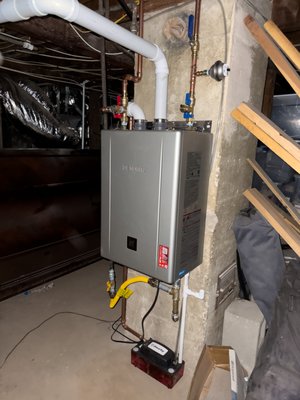 Tank to Tankless Conversion in Basement - This customer wanted to convert from an aging conventional tank water heater to a high-efficiency tankless system. The unit was located in the basement, which made for an interesting install. We ran new PVC venting to the side of the home with a proper termination cap to safely exhaust the unit.
Because today's high-efficiency tankless heaters are condensing units, they produce condensation while running — and this basement had no nearby drain at the right height to handle it. To solve that, we installed a condensate pump that safely collects the condensation and pumps it to the nearest drain, eliminating the pitch and drainage issue the location created.
The homeowner chose the new Noritz Pro tankless water heater with a built-in recirculation pump for fast hot water at the tap. This unit carries a top-tier 0.98 UEF efficiency rating — one of the highest available — which qualified it for a $1,500 SoCal Gas rebate, significantly lowering the cost of the upgrade. Tank to Tankless Conversion in Basement - This customer wanted to convert from an aging conventional tank water heater to a high-efficiency tankless system. The unit was located in the basement, which made for an interesting install. We ran new PVC venting to the side of the home with a proper termination cap to safely exhaust the unit.
Because today's high-efficiency tankless heaters are condensing units, they produce condensation while running — and this basement had no nearby drain at the right height to handle it. To solve that, we installed a condensate pump that safely collects the condensation and pumps it to the nearest drain, eliminating the pitch and drainage issue the location created.
The homeowner chose the new Noritz Pro tankless water heater with a built-in recirculation pump for fast hot water at the tap. This unit carries a top-tier 0.98 UEF efficiency rating — one of the highest available — which qualified it for a $1,500 SoCal Gas rebate, significantly lowering the cost of the upgrade.